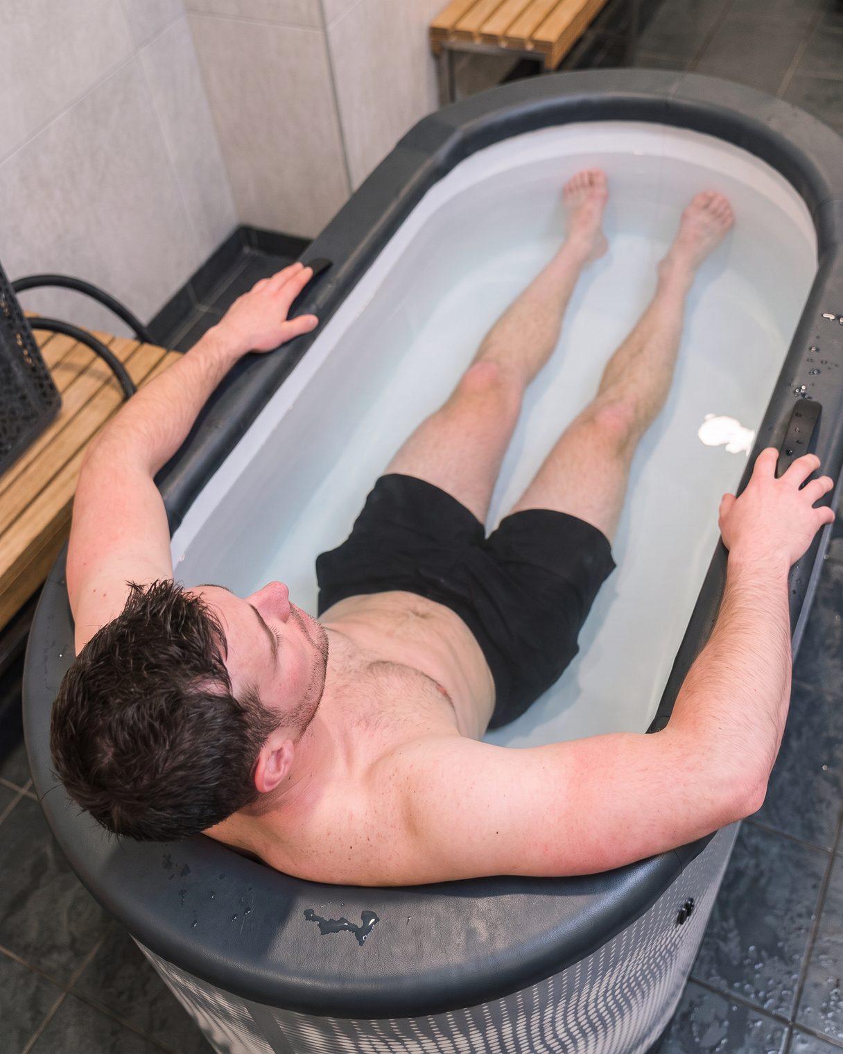 Deportista sentado en el baño de hielo Nordik Club dentro de su club tras entrenar